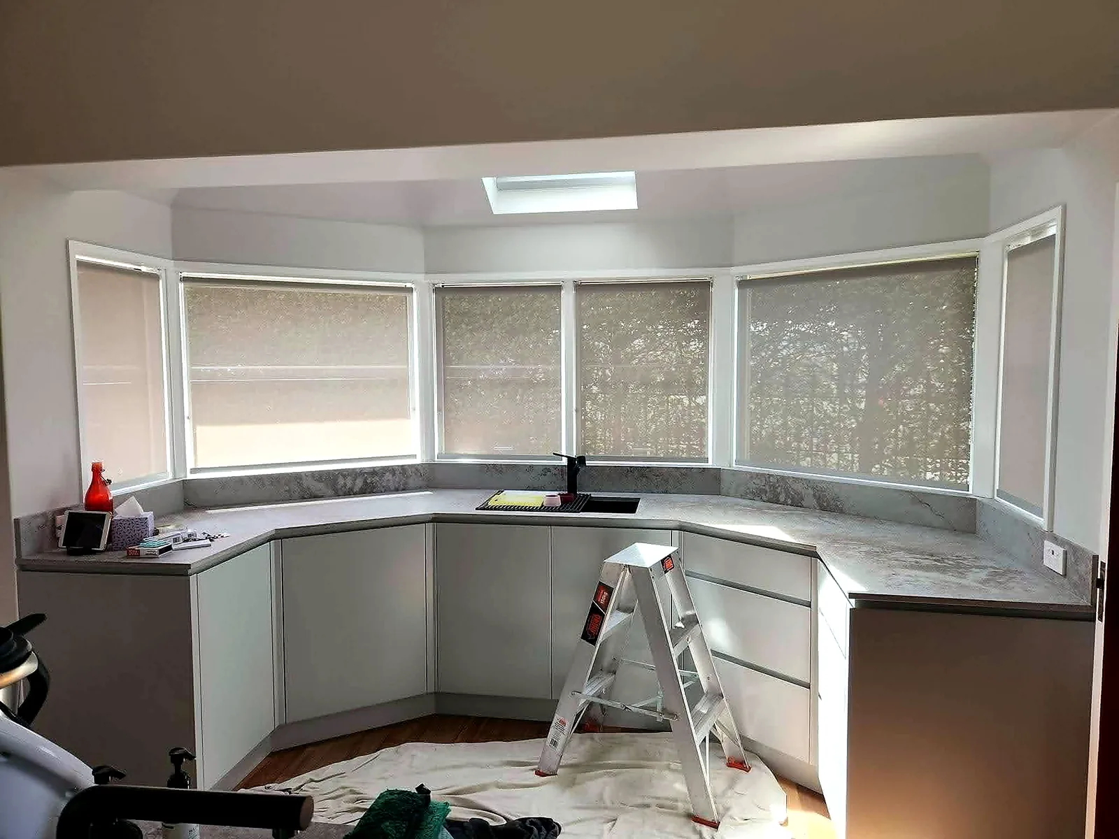 Roller blinds installed across a bay kitchen window in Brisbane